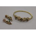 An 18ct gold, diamond and gem set hinged bracelet and a pair of matching earrings.