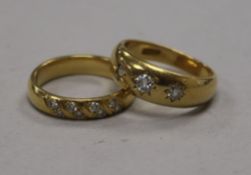 An 18ct gold and gypsy set three stone diamond ring and one other 18ct gold and diamond ring.