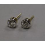 A modern pair of 18ct gold and collet set solitaire diamond ear studs.