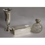 A late Victorian silver mounted scent bottle, a silver spill vase and a silver cigarette box.