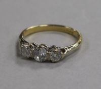 An 18ct gold and three stone diamond ring, size L.
