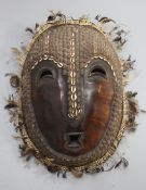 A Solomon Islands turtle shell mask, applied with shells and feathers, 42cm