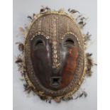 A Solomon Islands turtle shell mask, applied with shells and feathers, 42cm