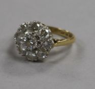 An 18ct gold and platinum, nine stone diamond cluster ring, size L.