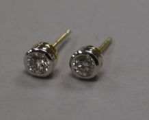 A modern pair of 18ct gold and collet set solitaire diamond ear studs.