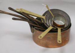 Thirteen graduated copper saucepans