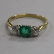 An 18ct gold, three stone emerald and diamond ring, size S.