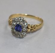 A late Victorian 18ct gold, sapphire and diamond oval cluster ring, size V/W.