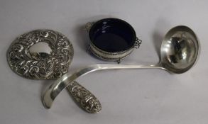 A repousse silver hand mirror, a pierced silver butter dish and liner and a plated soup ladle.