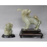 Two Chinese celadon jade figures of a fisherman and a lion-dog, 6.2 and 11cm, wood stands