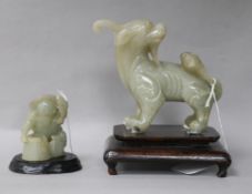 Two Chinese celadon jade figures of a fisherman and a lion-dog, 6.2 and 11cm, wood stands