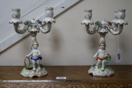 A pair of floral encrusted figural four branch candelabra