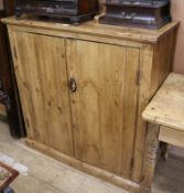 A plain stripped pine two door cupboard W.106cm