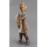 An African carved softwood figure of a man holding a shield, 31cm