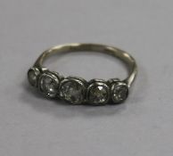 An early 20th century 18ct gold and graduated collet set five stone diamond ring, size O.