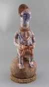 An Ibo People of Nigeria painted terracotta shrine vessel, surmounted with the figure of a seated