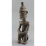 An African carved wood figure of a seated man, 35cm