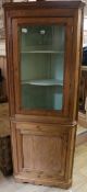 A stripped pine standing corner cupboard with glazed upper section W.71cm