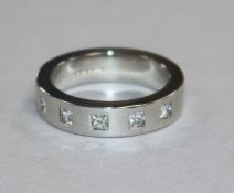 A modern platinum and gypsy set five stone diamond ring, gross 17 grams, size O.