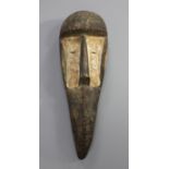 A carved wood bird beak mask, with iron studded and whitened decoration, 45cm