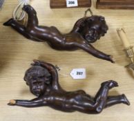 A pair of carved wood cherubs length 43cm
