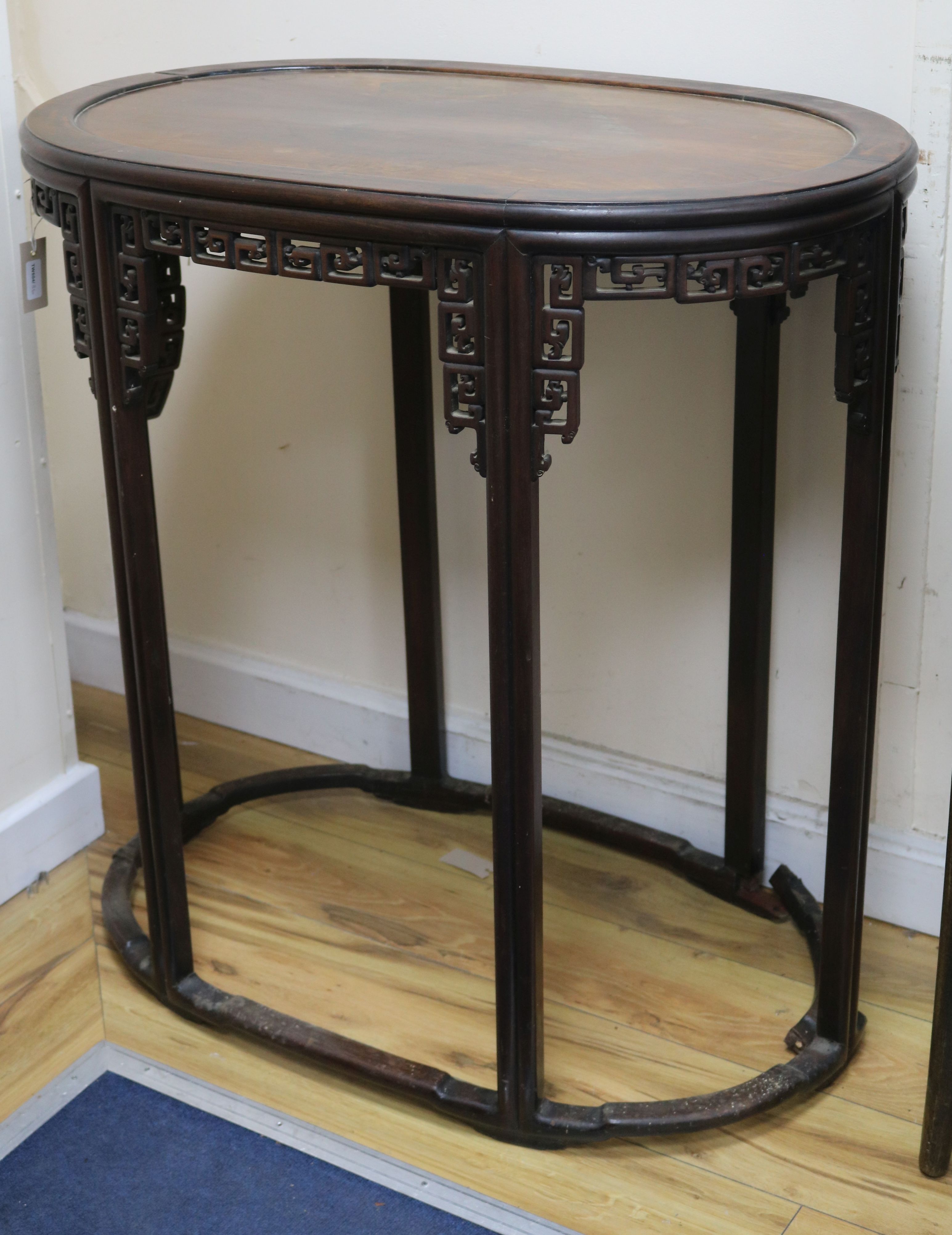 A Chinese carved hardwood oval pedestal table with pierced frieze and peripheral stretcher W.87cm