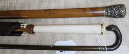 An Indian silver topped malacca cane, a horn dog's head stick and an ivory handled umbrella