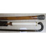 An Indian silver topped malacca cane, a horn dog's head stick and an ivory handled umbrella