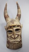 An African carved and painted wood mask, with raised horns, 74cm