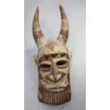 An African carved and painted wood mask, with raised horns, 74cm