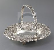 A George IV pierced silver oval cake basket by Robert Gainsford, embossed with flowers and scrolls