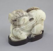 A Chinese pale celadon and black jade recumbent figure of a winged mythical beast, length 7cm,