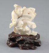 A Japanese ivory group of Kinko riding a carp, Meiji period, unsigned, one inlaid eye lacking,