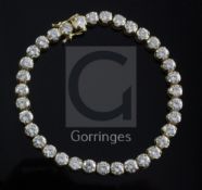 An 18ct gold and diamond line bracelet, set with thirty five round brilliant cut diamonds with a