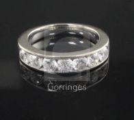 A modern 18ct white gold and channel set seven stone diamond half hoop ring, size M.