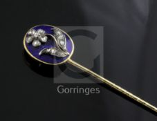 A late Georgian yellow metal and blue enamel stick pin, the oval head set with rose diamonds in a