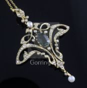 An Edwardian 15ct gold tourmaline and seed pearl set scroll drop pendant, on a 15ct gold chain