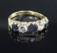 An 18ct gold, sapphire and diamond five stone half hoop ring, set with three round cut sapphires and