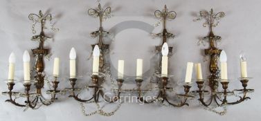 A set of four ormolu three branch wall lights c.1900, with dragon's head and mask stems, lustre hung