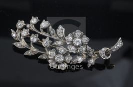 An early 20th century gold, silver and diamond set floral spray brooch, 60mm.