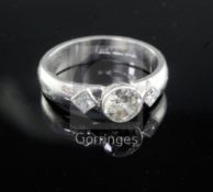 A modern platinum and single stone diamond dress ring with princess cut diamond set shoulders,