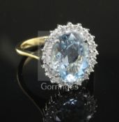 A modern 18ct gold, aquamarine and diamond oval dress ring, size O.
