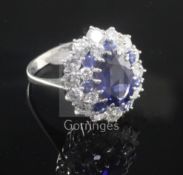 A modern 18ct white gold, sapphire and diamond oval cluster dress ring, size O.