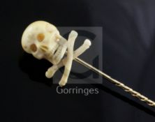 A Victorian gold stick pin with ivory skull and crossbones terminal, 75mm.