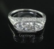 A 1950's/1960's platinum and three stone diamond ring, with pierced and carved shank and