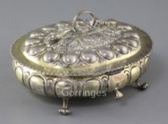 A late Victorian embossed silver gilt oval casket, By Carrington & Co, with fluted body, and ring