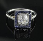 A 1920's/1930's platinum, diamond and sapphire cluster ring, of tablet form, the central cushion cut