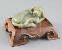 A Chinese green jade figure of a recumbent dog, the stone with slight brown inclusions, length 12.