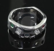 A modernist wavy design 18ct white gold, emerald, ruby, sapphire and baguette cut diamond gypsy
