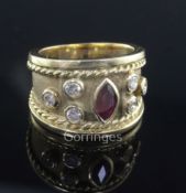 A modern 18ct gold and collet set ruby and diamond dress ring, the central marquise shaped ruby